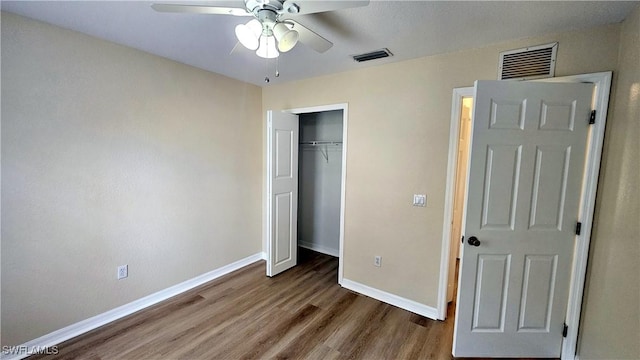 unfurnished bedroom with a closet, ceiling fan, and dark hardwood / wood-style flooring