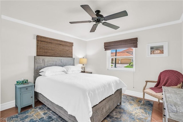 bedroom with dark tile patterned floors, ornamental molding, and ceiling fan