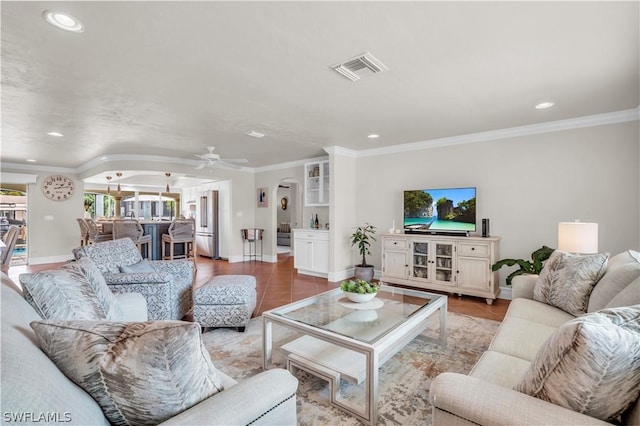 living room featuring crown molding, light tile patterned floors, and ceiling fan