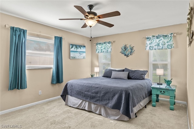 carpeted bedroom featuring multiple windows and ceiling fan