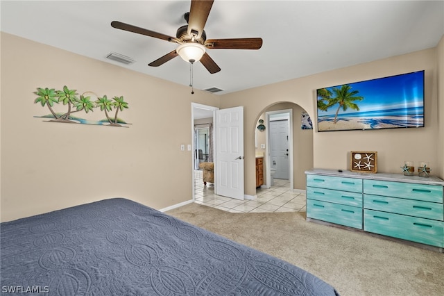 unfurnished bedroom with arched walkways, carpet floors, tile patterned flooring, and visible vents