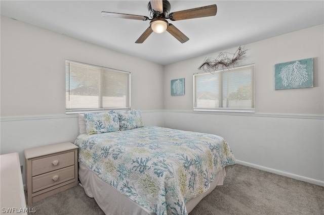 carpeted bedroom featuring multiple windows, ceiling fan, and baseboards