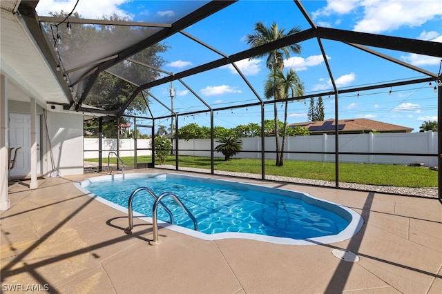 view of swimming pool with a patio, a lanai, and a lawn