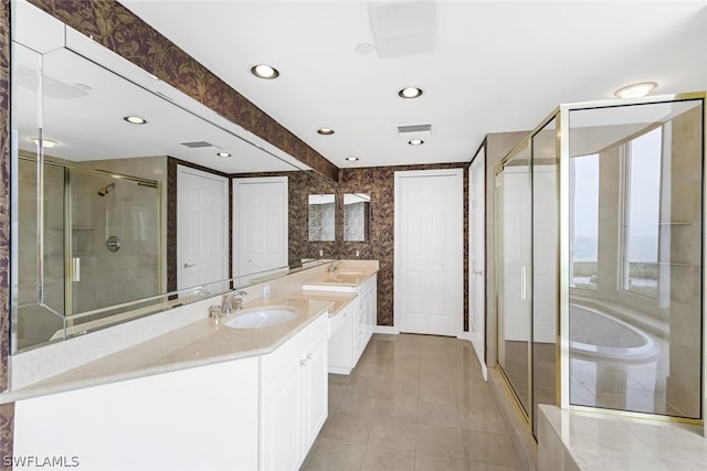 bathroom featuring visible vents, double vanity, a stall shower, a sink, and a bath