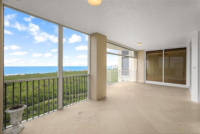 unfurnished sunroom featuring a water view