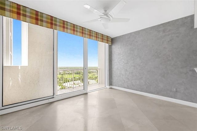 spare room with wallpapered walls, baseboards, and a ceiling fan