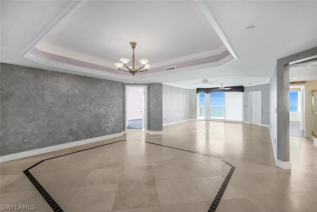 spare room featuring a tray ceiling, visible vents, and baseboards