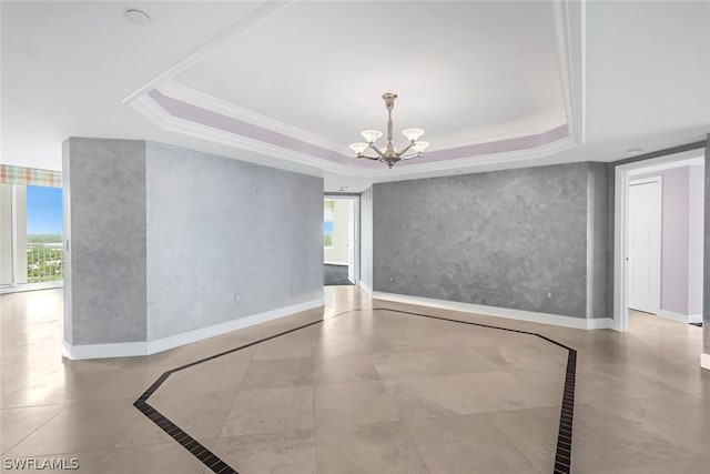 unfurnished room featuring a wealth of natural light, a raised ceiling, and baseboards