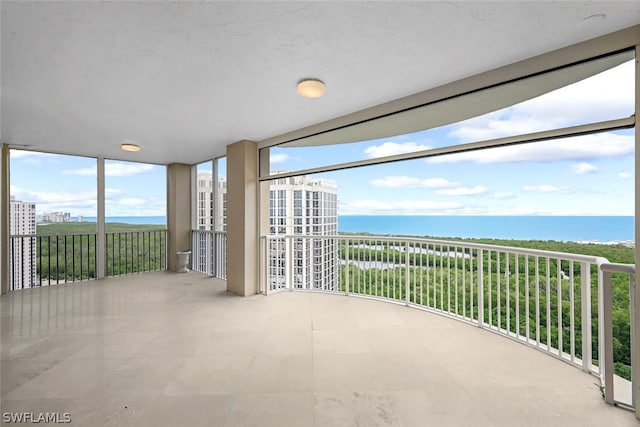 unfurnished sunroom featuring a water view