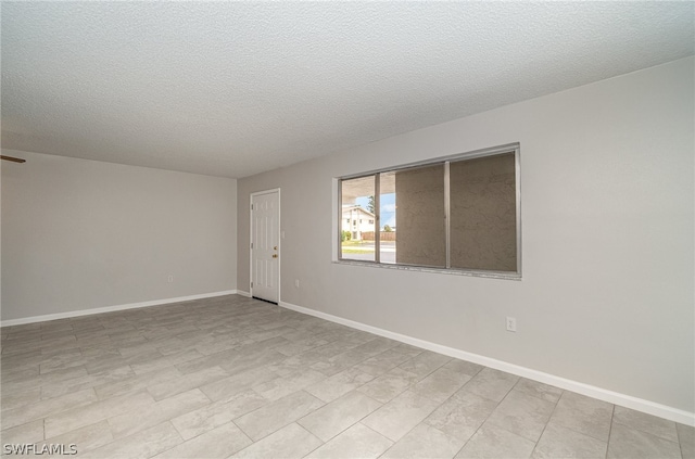 unfurnished room with a textured ceiling