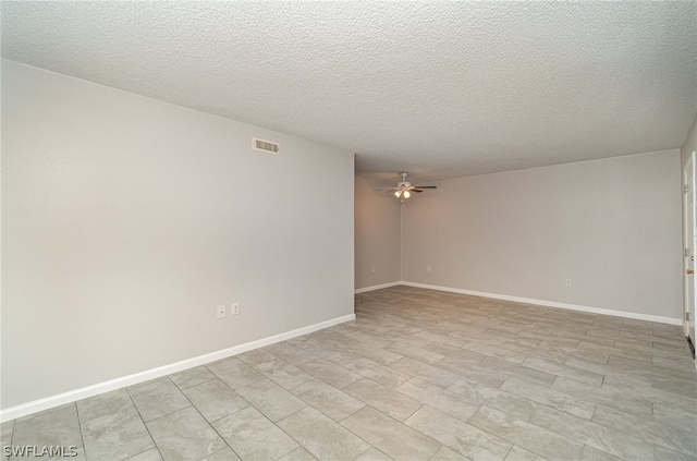 unfurnished room with ceiling fan and a textured ceiling