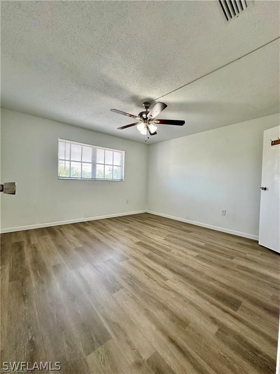 unfurnished room with hardwood / wood-style floors, ceiling fan, and a textured ceiling