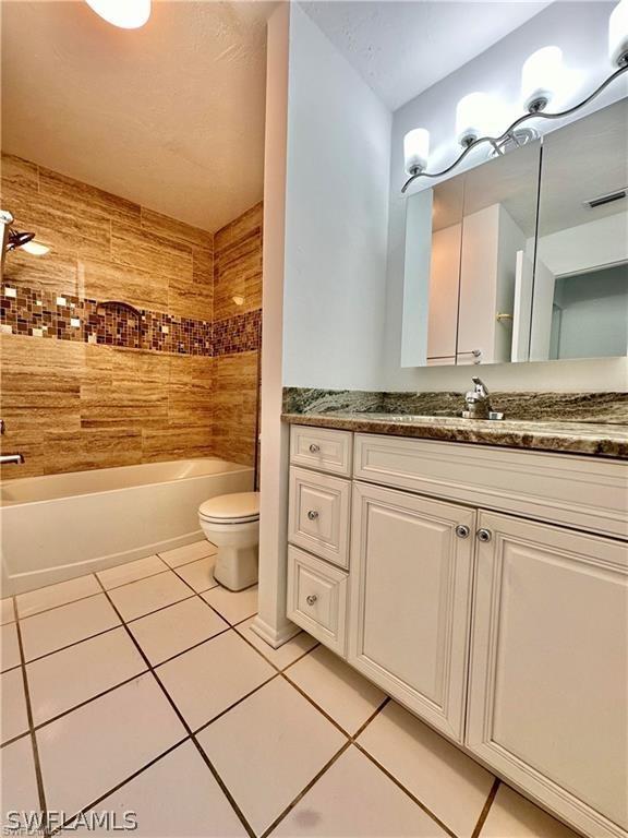 full bathroom with tile patterned flooring, vanity, toilet, and tub / shower combination