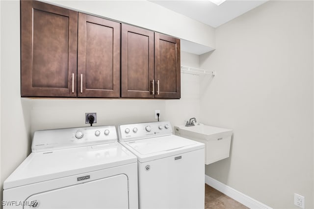 clothes washing area with cabinets, sink, and washing machine and dryer