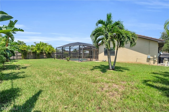 view of yard with a fenced in pool and glass enclosure