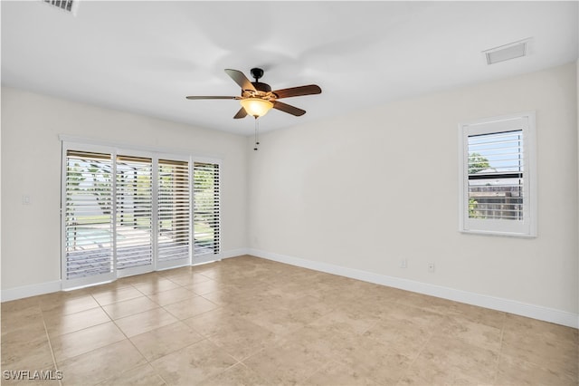 empty room featuring light tile patterned floors, plenty of natural light, and ceiling fan