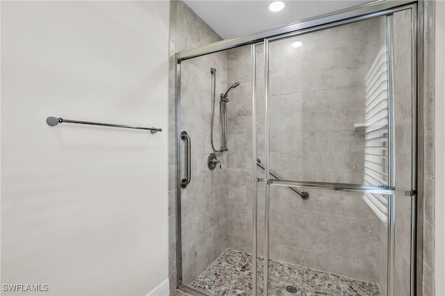 bathroom featuring a shower with door