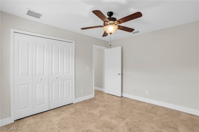 unfurnished bedroom with ceiling fan and a closet