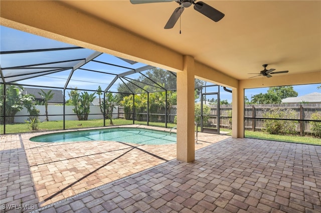 view of pool with a lanai, a lawn, ceiling fan, and a patio area