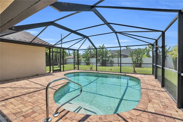 view of swimming pool featuring a patio, a lanai, and a lawn