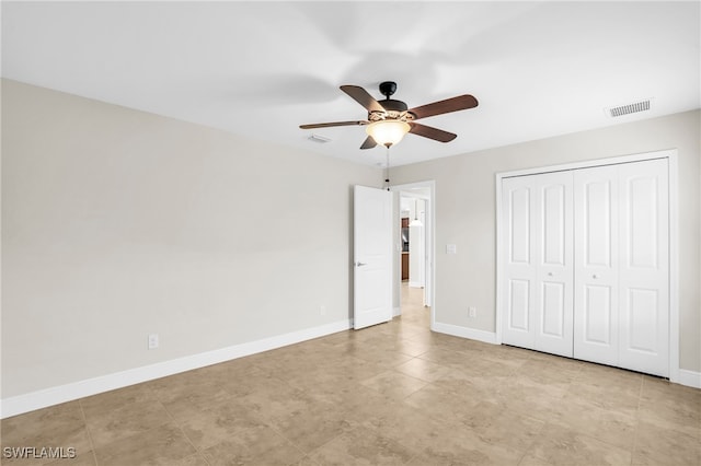 unfurnished bedroom featuring ceiling fan and a closet