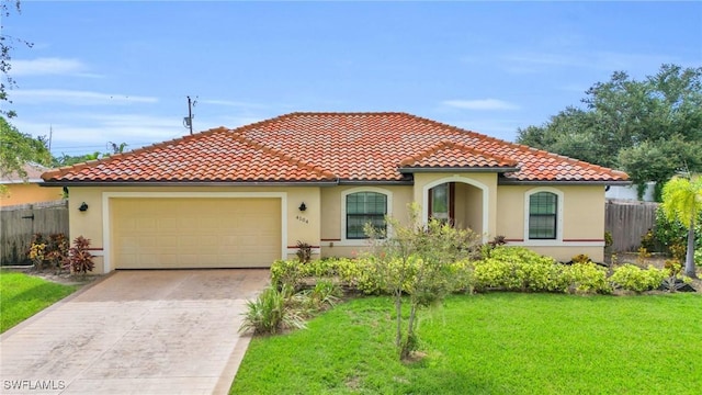 mediterranean / spanish house featuring a garage and a front yard