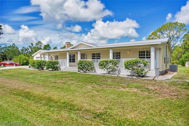 view of front of property with a front lawn, central AC unit, covered porch, and a chimney