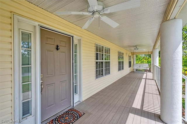 wooden terrace featuring a porch and ceiling fan