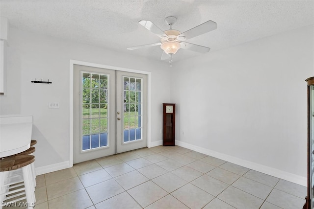 tiled spare room with french doors, ceiling fan, and a textured ceiling