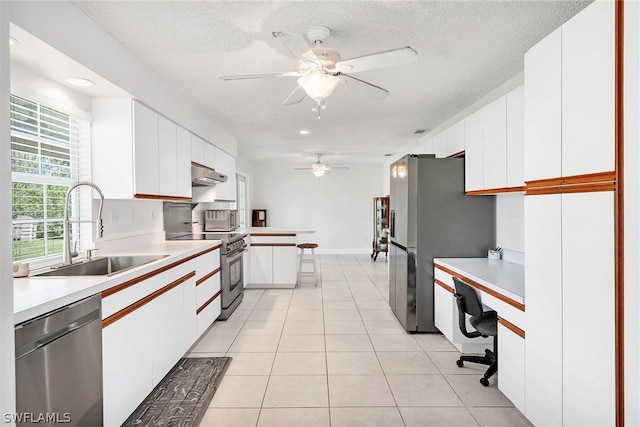 kitchen featuring white cabinets, appliances with stainless steel finishes, light tile patterned floors, and ceiling fan