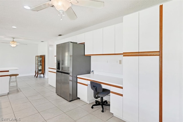 office space featuring light tile patterned flooring, a textured ceiling, and ceiling fan