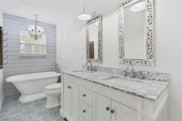 bathroom featuring toilet, tile patterned flooring, dual bowl vanity, and a chandelier