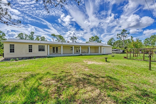 rear view of property with a yard