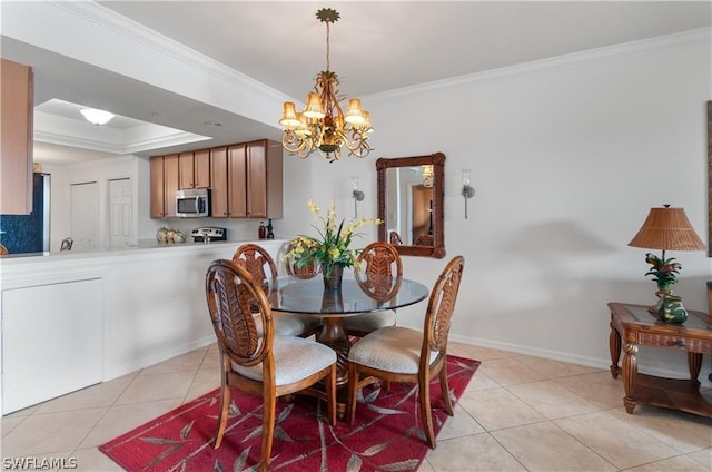 tiled dining room featuring a tray ceiling, crown molding, and a chandelier