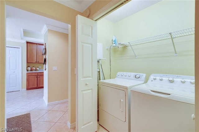 laundry area featuring washing machine and dryer, light tile patterned flooring, and crown molding