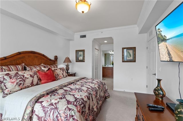 carpeted bedroom with ensuite bath and ornamental molding