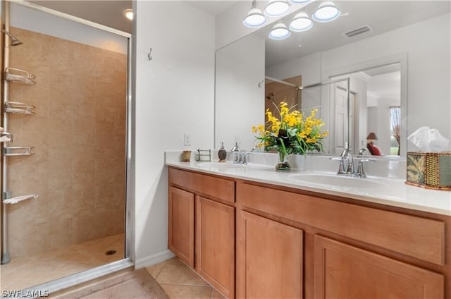 bathroom with vanity, tile patterned flooring, and a tile shower