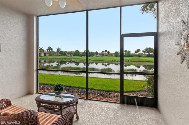 sunroom featuring a water view