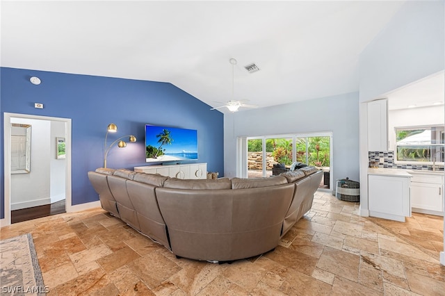 living room with ceiling fan and vaulted ceiling