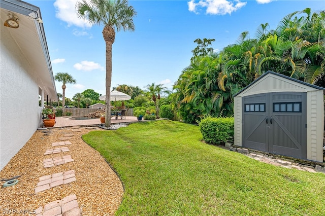 view of yard featuring a storage shed and a patio area