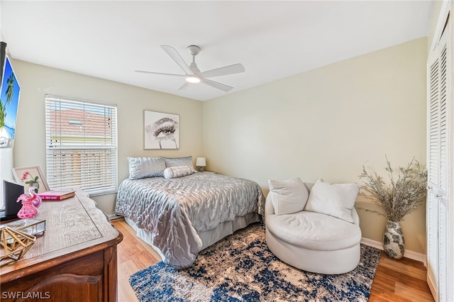 bedroom with ceiling fan, light hardwood / wood-style floors, and a closet