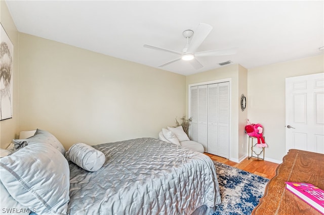 bedroom featuring hardwood / wood-style flooring, ceiling fan, and a closet