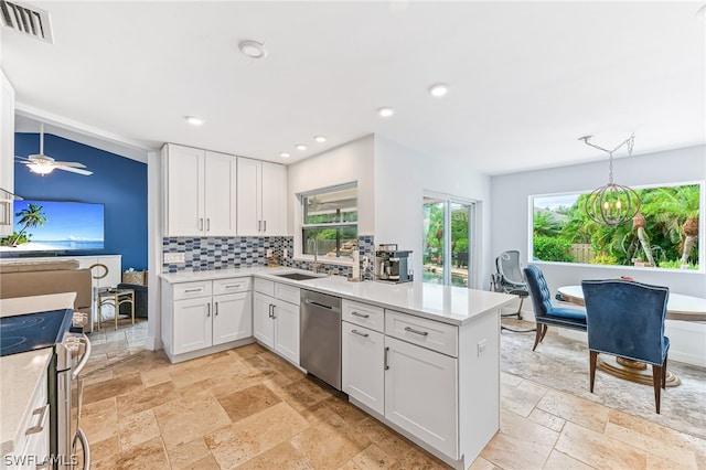 kitchen with backsplash, kitchen peninsula, white cabinets, and appliances with stainless steel finishes