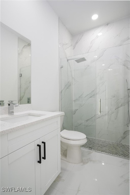 bathroom featuring vanity, toilet, and a shower with shower door