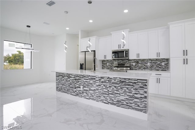 kitchen with sink, pendant lighting, white cabinets, and stainless steel appliances