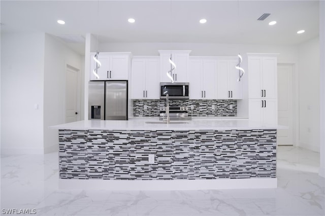 kitchen featuring sink, a kitchen island with sink, stainless steel appliances, and white cabinets