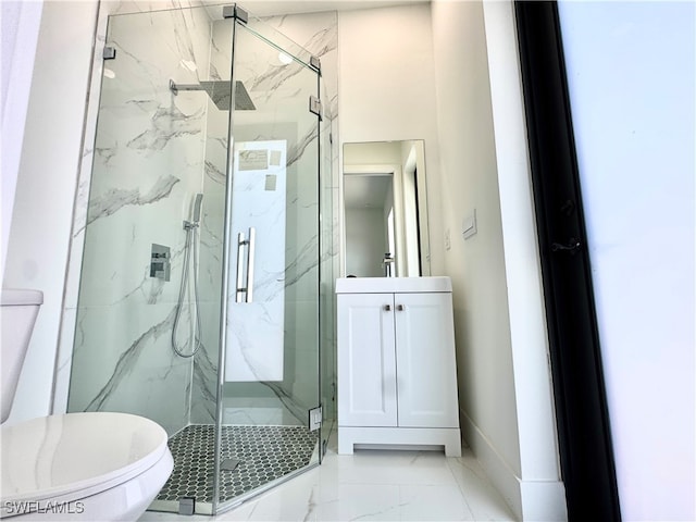 bathroom featuring a shower with door, vanity, and toilet