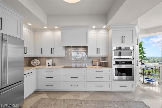 kitchen featuring tasteful backsplash, light stone counters, stainless steel appliances, and white cabinets