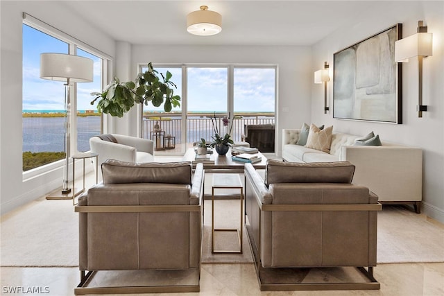 living room featuring light tile patterned flooring, a water view, and a wealth of natural light