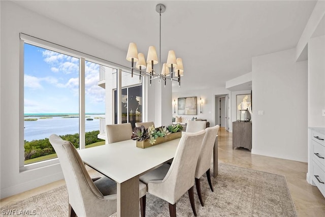 dining space featuring a water view and an inviting chandelier